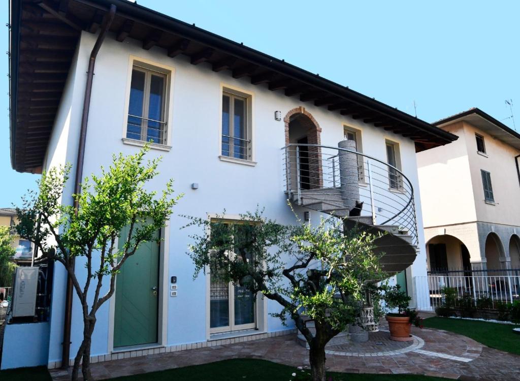 una casa bianca con una scala in un cortile di B&B Bagnolo Mella a Bagnolo Mella