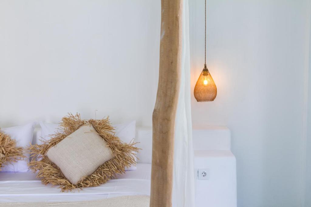 a room with a bed with a pillow and a lamp at Guru Canggu in Canggu