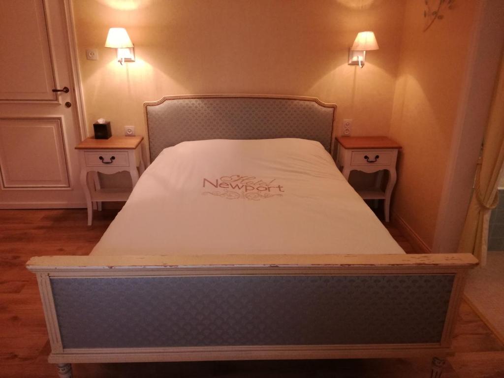 a bed in a room with two night stands at B&B El Tyu in Écaussinnes-dʼEnghien