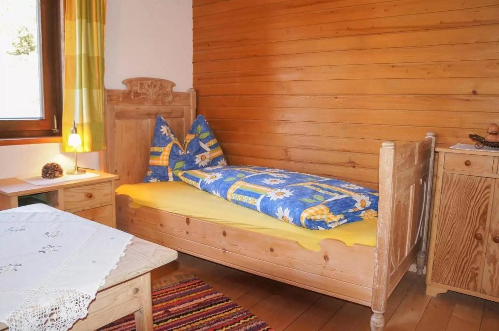 sypialnia z łóżkiem i drewnianą ścianą w obiekcie Rosas Ferienwohnung w mieście Fieberbrunn