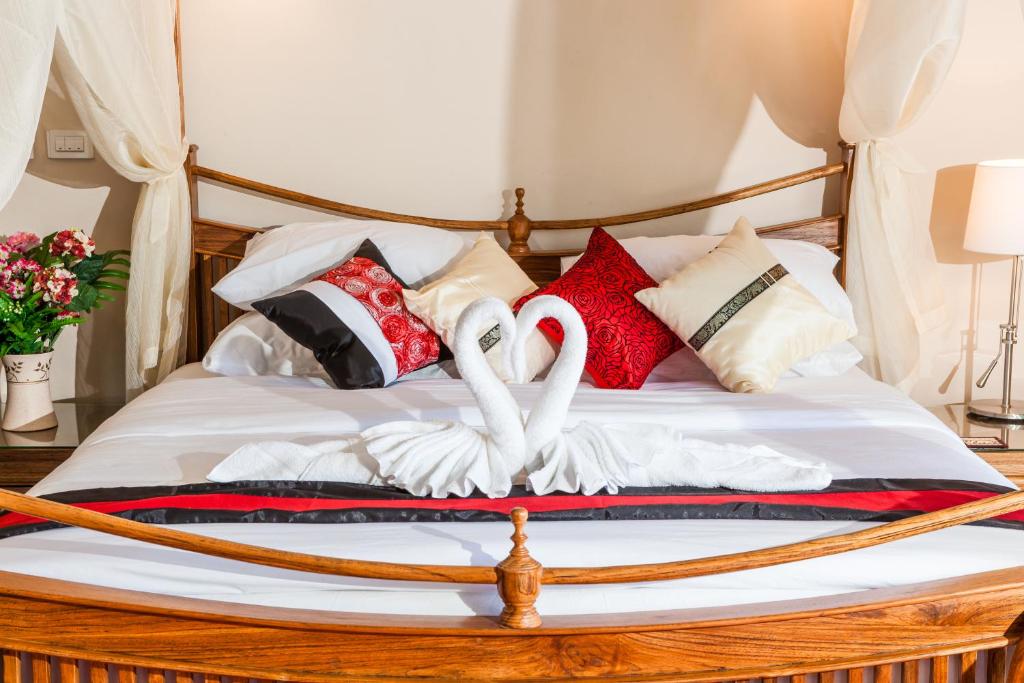 a bed with a bunch of pillows on it at Samui Sunrise Seaview Villa in Chaweng