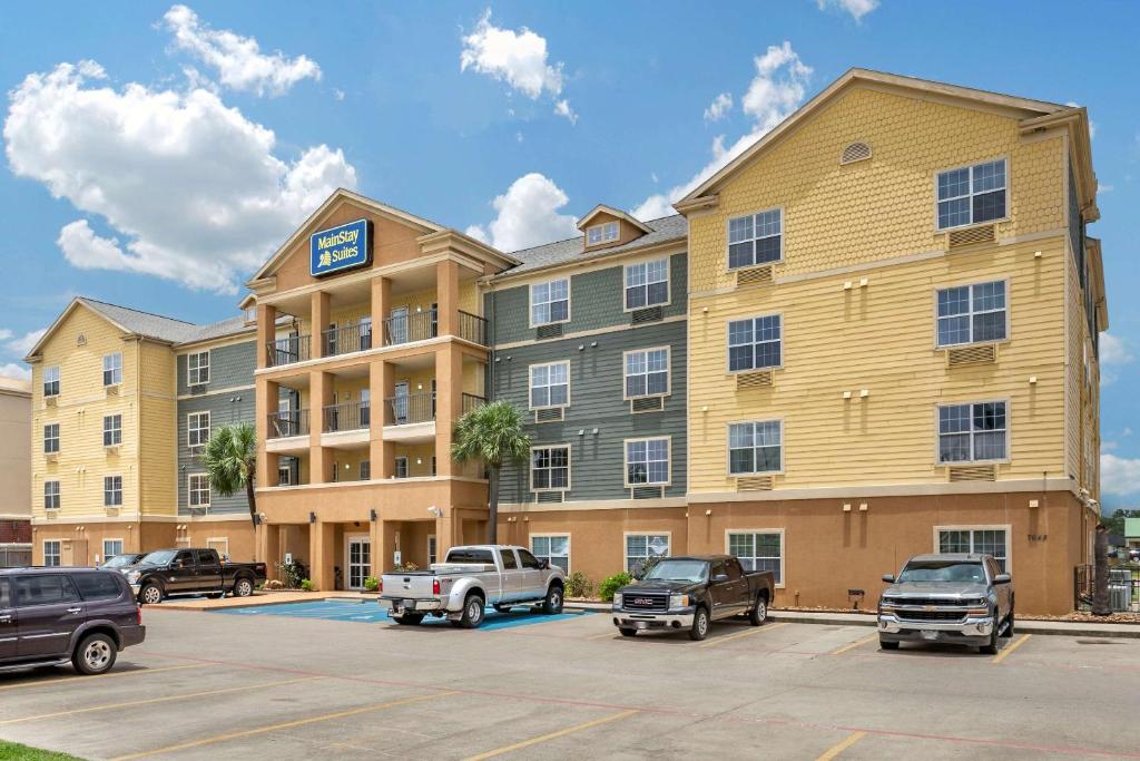 un gran edificio de apartamentos con coches aparcados en un aparcamiento en MainStay Suites Port Arthur - Beaumont South, en Port Arthur