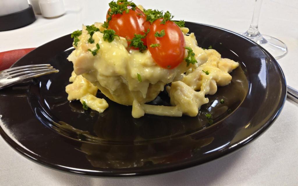 un plato negro con pasta y tomates en una mesa en Hotel Korning Kro en Korning