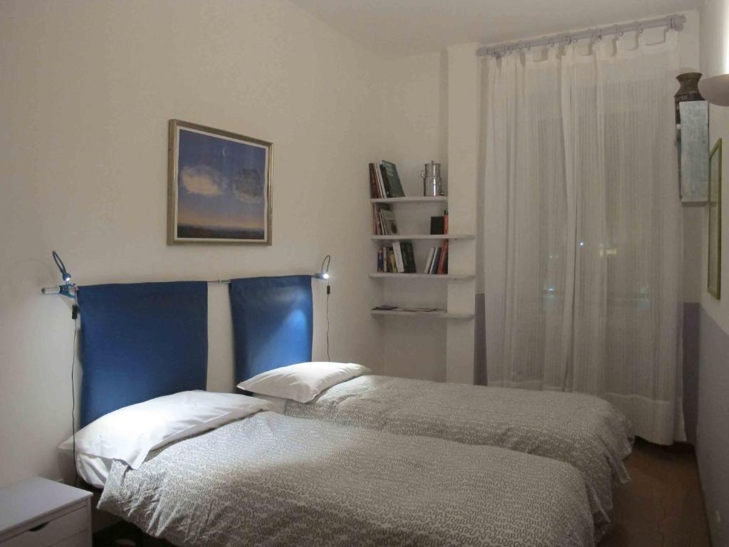 a bedroom with a bed with a blue headboard and a window at Bernini apartment in Rome