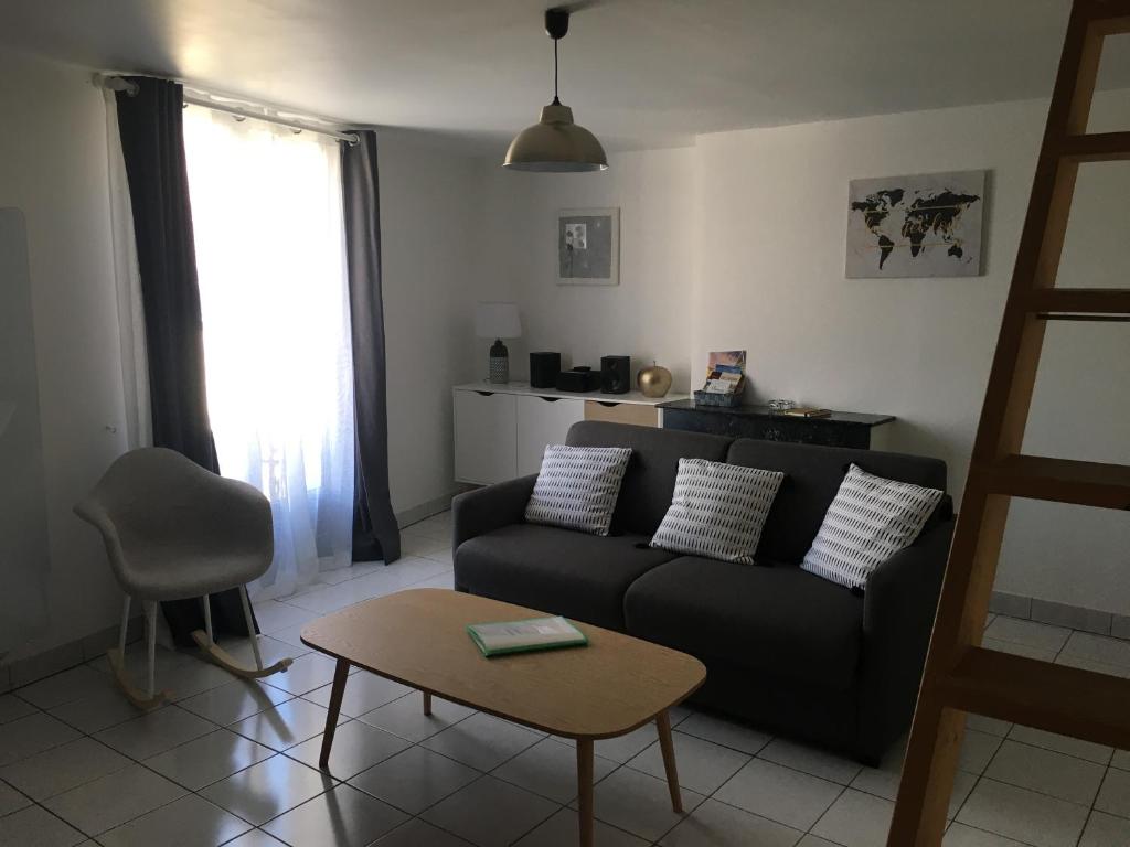 ein Wohnzimmer mit einem Sofa und einem Tisch in der Unterkunft L Ecrin, duplex classé 2 étoiles, au cœur de Villandry in Villandry