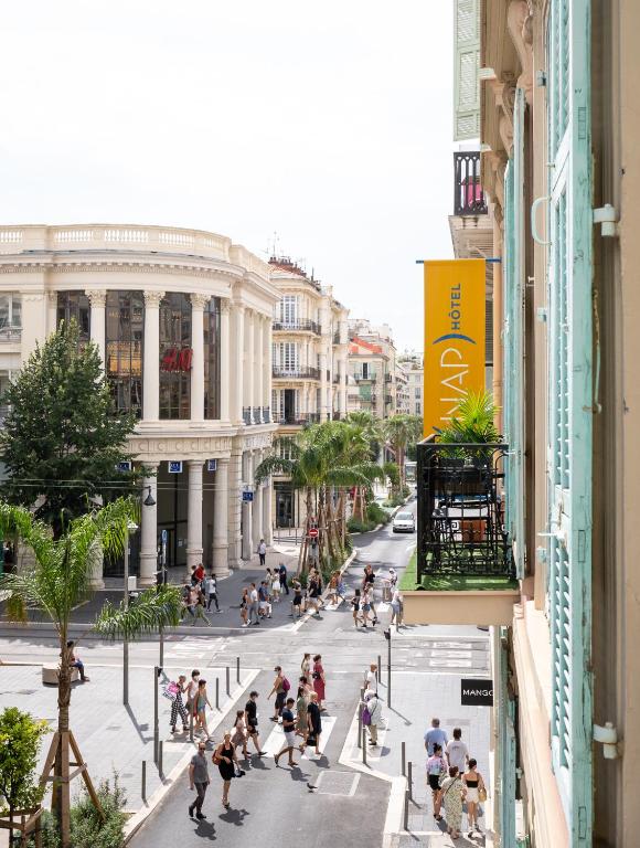 a group of people crossing a street in a city at Hotel Nap By HappyCulture in Nice