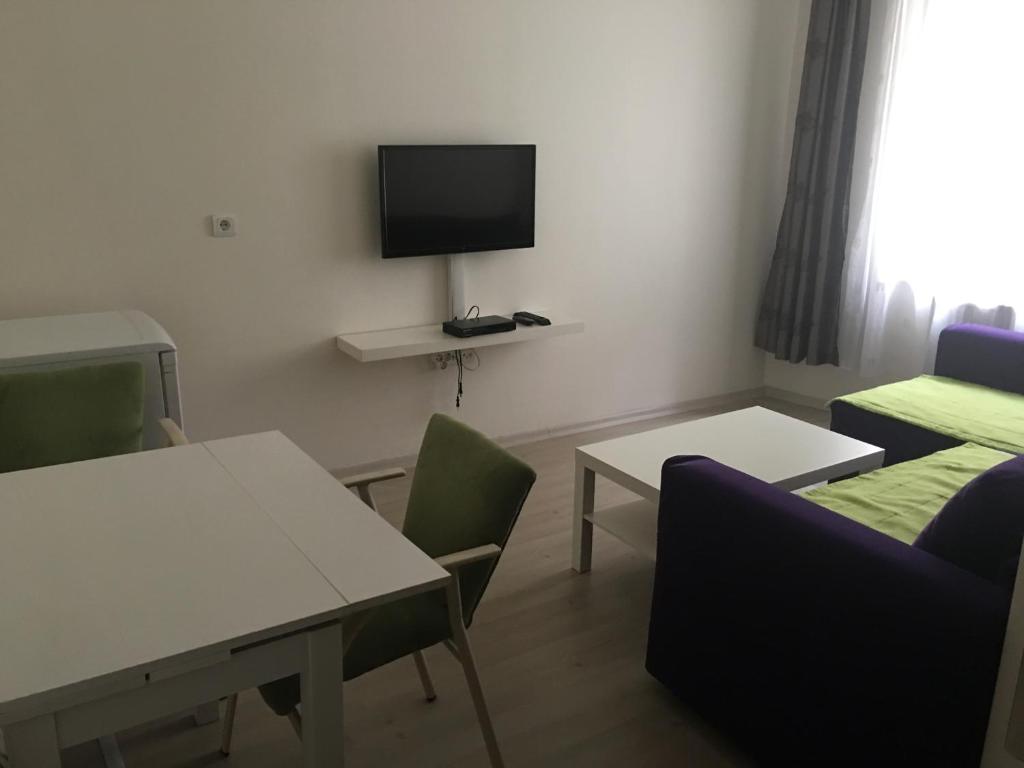 a room with tables and chairs and a tv on the wall at A Hotels & Suite in Ankara