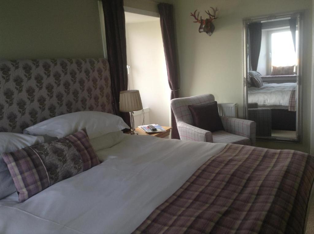 a bedroom with a bed and a chair and a mirror at 3 Braehead in Thurso