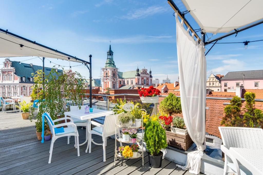 balcón con mesas y sillas y vistas a la ciudad en Hotel Kolegiacki en Poznan