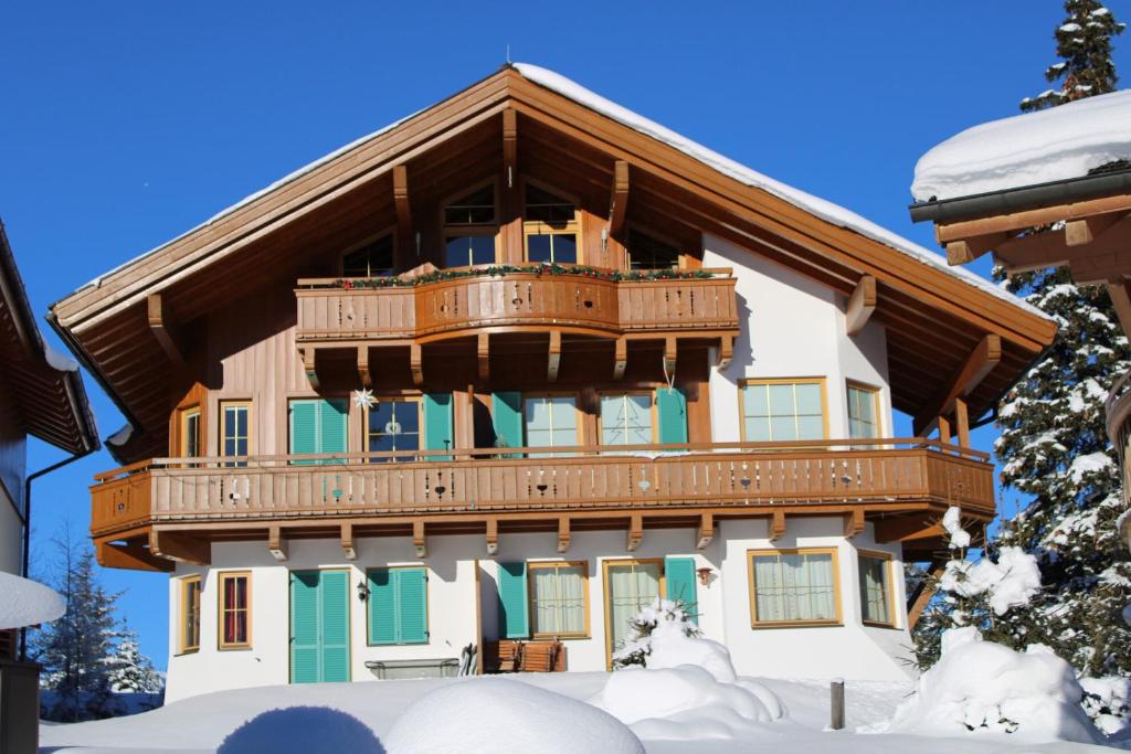 a large building with a balcony in the snow at Filzsteinalpe Hochkrimml in Krimml