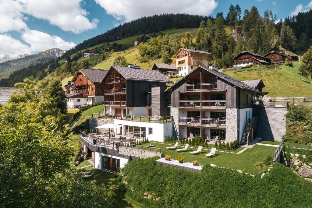 an aerial view of a house on a hill at Les Dolomites Mountain Lodges in San Martino in Badia
