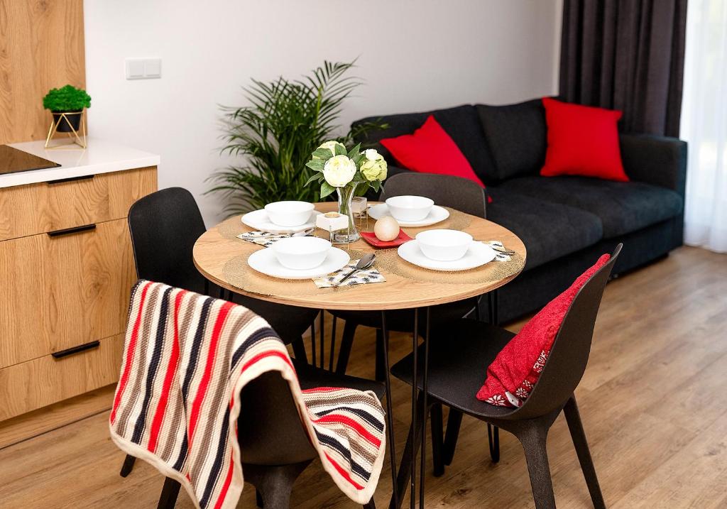 a dining room table with chairs and a couch at VIP Apartamenty number 6 in Lublin