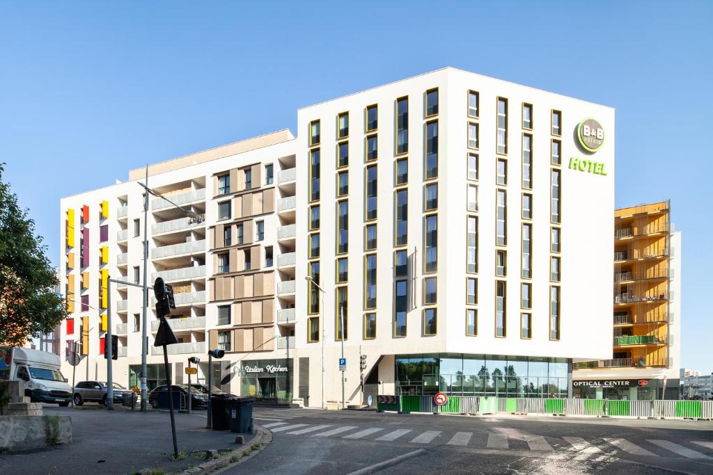 a white building on a city street with a traffic light at B&B HOTEL Paris Porte de Bagnolet in Bagnolet