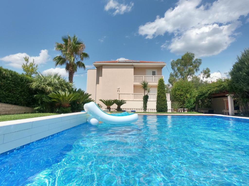 una piscina con un tobogán frente a una casa en Villa Keti apartments Pool & Wellness en Splitska