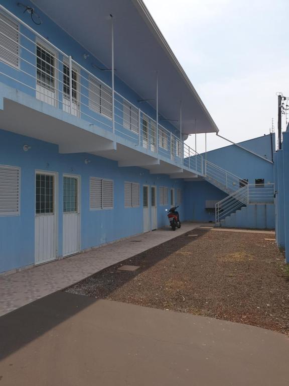 a blue building with a motorcycle parked next to it at Kitnet Camilóca 1 in Campo Grande