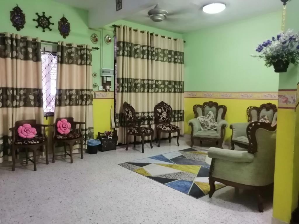 a living room with chairs and a table at KLUANG BARAT HOMESTAY in Kluang