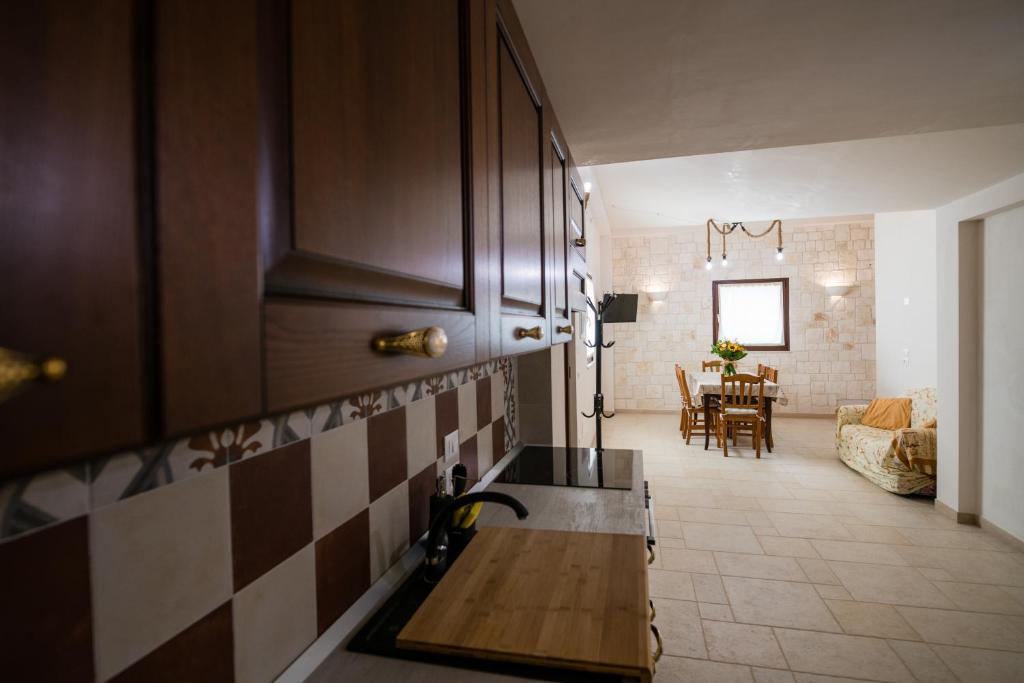 cocina con fregadero y sala de estar. en Masseria Mezza Ruota, en Alberobello