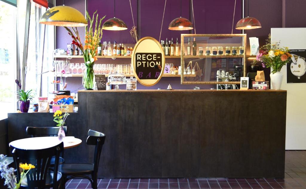 a bar in a restaurant with a table and chairs at Hostel 77 Bern in Bern