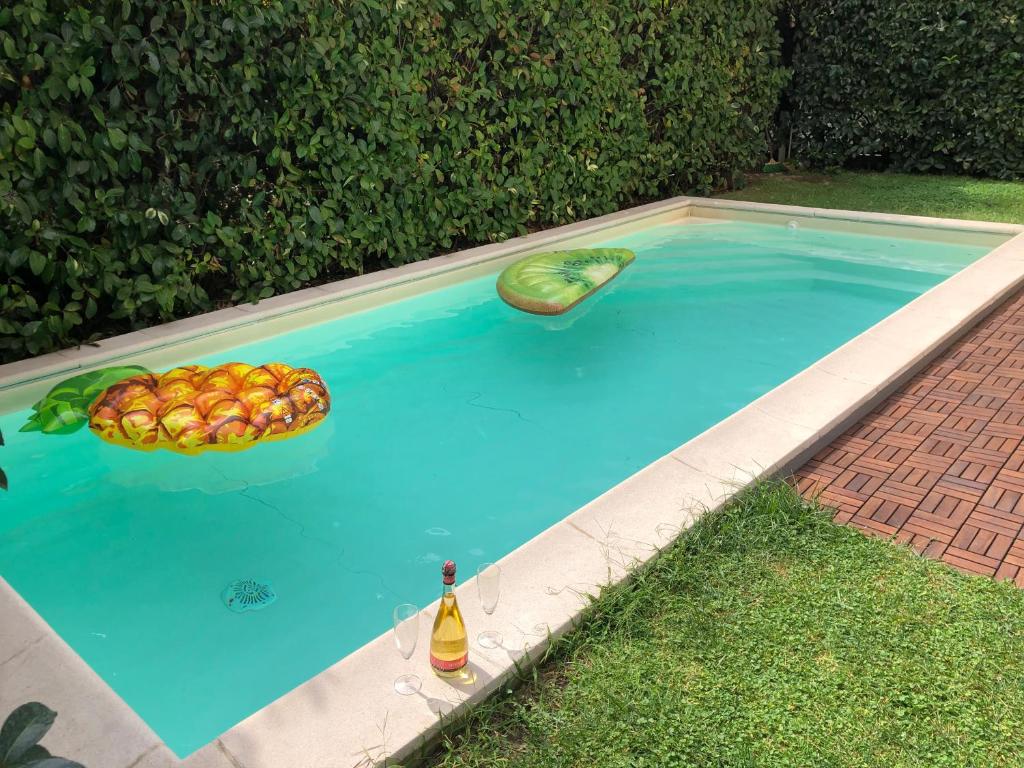 Villa Capri Apartment and Room في نابولي: صحن فاكهة وزجاجة في حمام سباحة