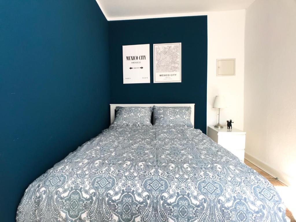 una camera con un letto con una parete blu di Dream Green Apartment 'Frida' a Gladenbach