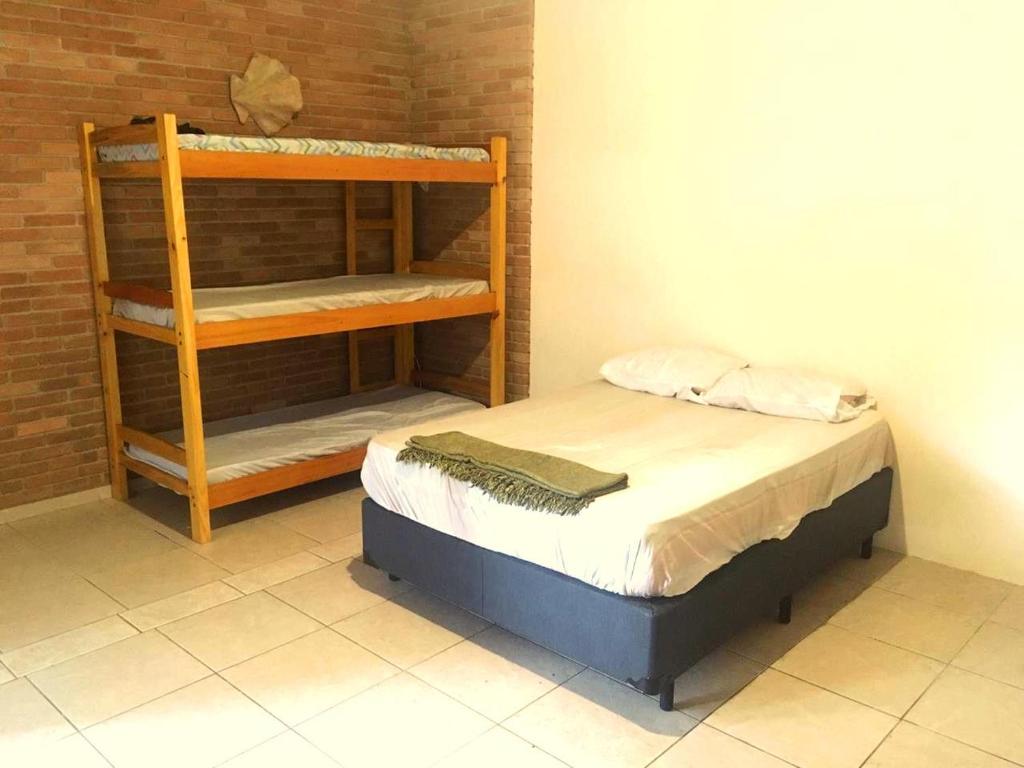 a small bedroom with a bunk bed and a shelf at Pousada Hostel Brazil Backpackers in Guarujá