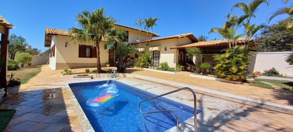 a house with a swimming pool in front of a house at Casa Pampulha in Belo Horizonte