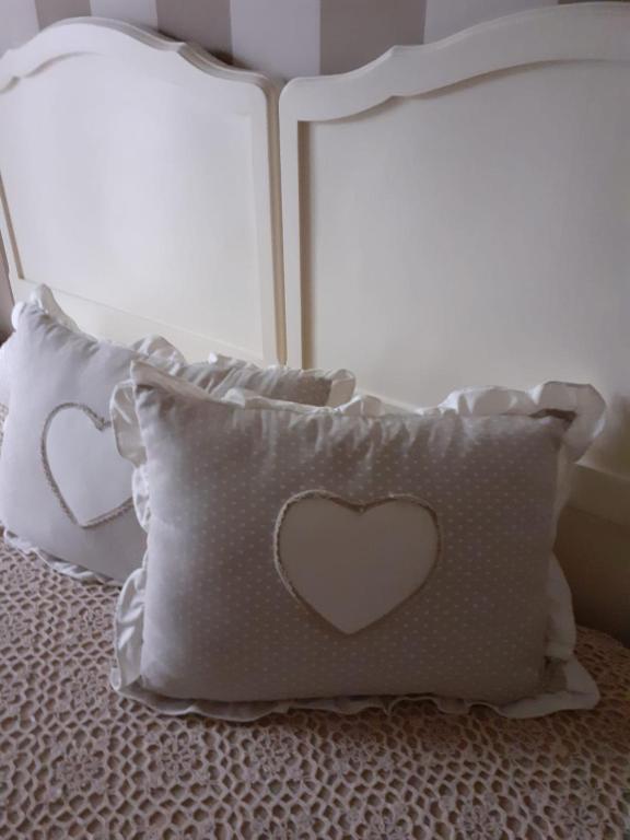 un cuscino con un cuore sopra, seduto su un letto di Casa Spina a San Giovanni Teatino
