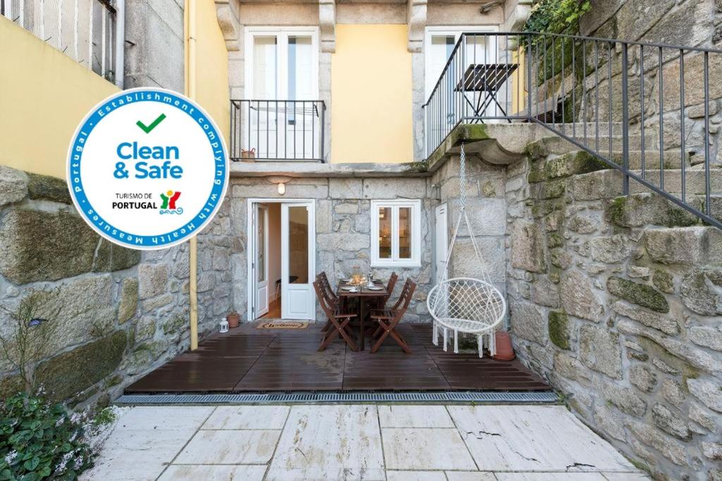 a sign in front of a building with a table and chairs at LovelyStay - Porto Peaceful Living W/ Backyard in Porto