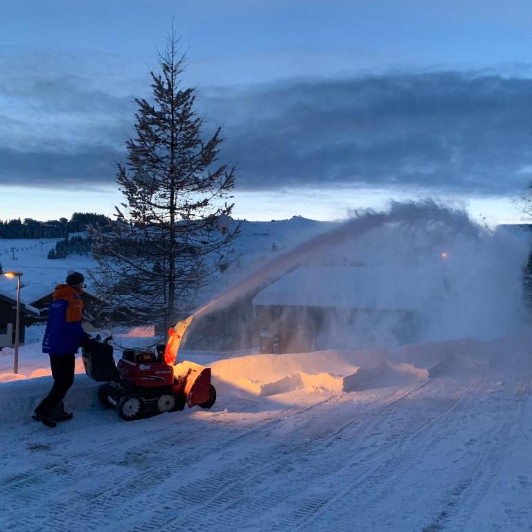 a person is using a snow blower to remove snow at APPARTEMENT PLEIN SUD AUX SAISIES N°6 in Les Saisies