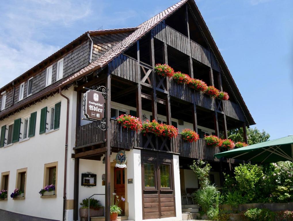 un bâtiment avec des boîtes de fleurs sur son côté dans l'établissement Landgasthof Adler, à Künzelsau
