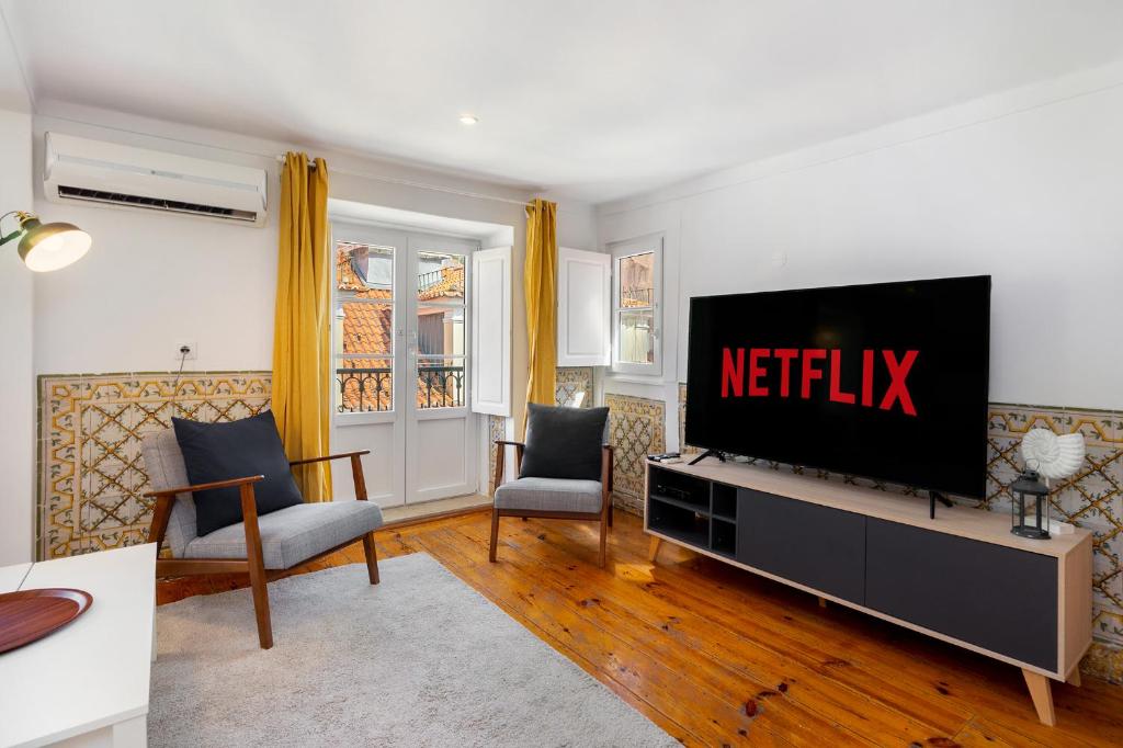 a living room with a flat screen tv on a entertainment center at WHome Charming and historical apartment in Santa Justa in Lisbon