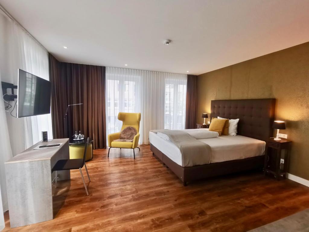 Habitación de hotel con cama, escritorio y silla en H23 Hotel Stuttgart, en Stuttgart