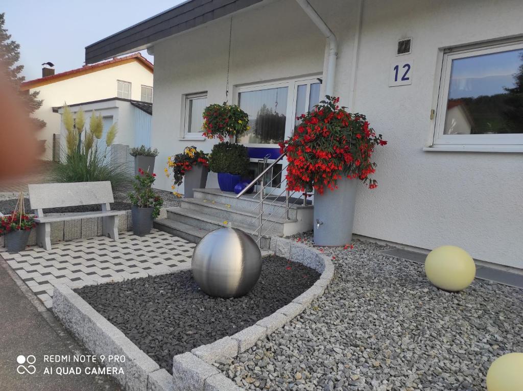 ein Haus mit einem silbernen Ball im Vorgarten in der Unterkunft Ferienwohnung Gartenblick in Ensingen