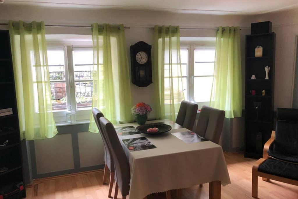 a dining room with a table and a clock on the wall at In the Heart of the Island in Lindau