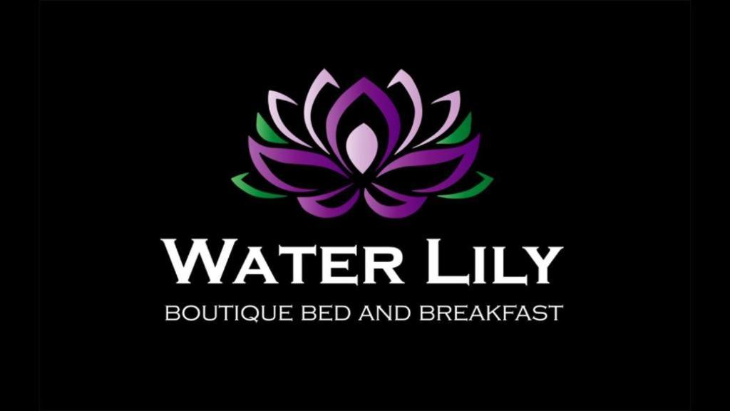 Water Lily Boutique B&B and Bungalow في هفيز: شعار زنبق الماء الأرجواني على خلفية سوداء
