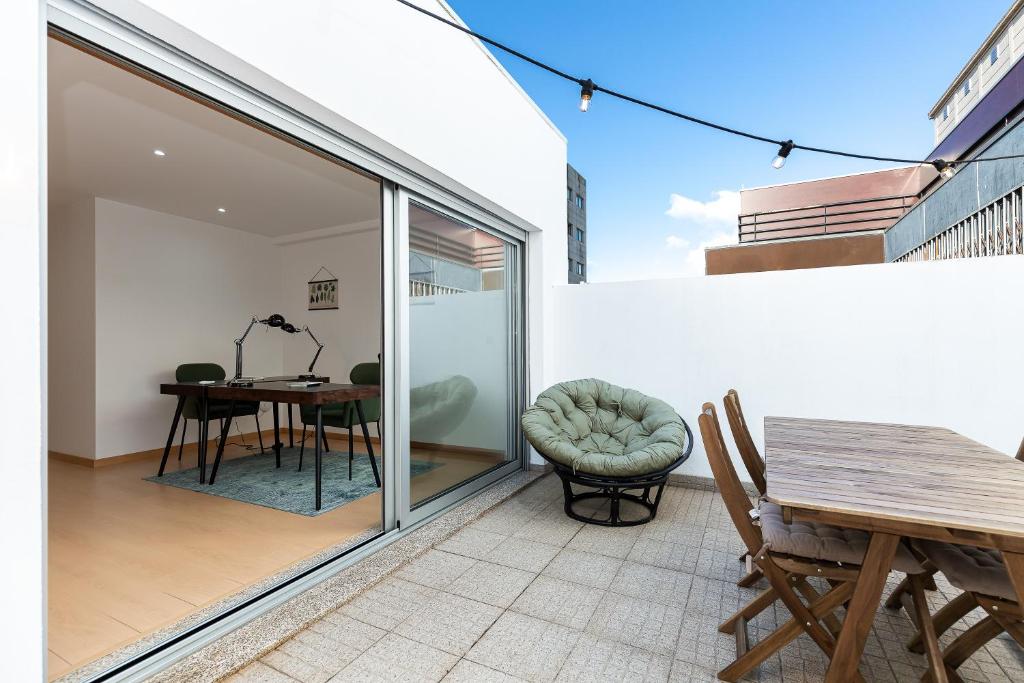 a patio with a table and chairs and a glass door at Feel Porto Corporate Housing Marquês in Porto
