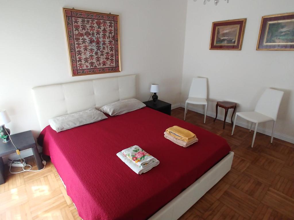 sypialnia z dużym łóżkiem i czerwonym kocem w obiekcie Casa Cristina w Rapallo