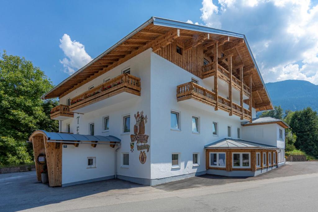 a large white building with a wooden roof at Home-Hotel Salzberg in Berchtesgaden