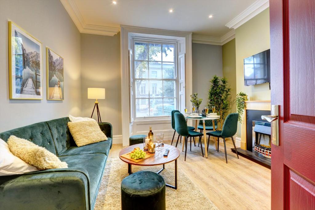 uma sala de estar com um sofá verde e uma mesa em Portland Street Leamington Spa Apartments em Leamington Spa