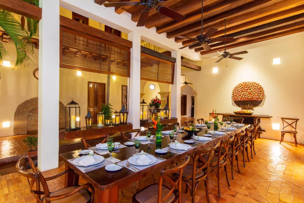 a dining room with a long table and chairs at Hotel Quadrifolio in Cartagena de Indias