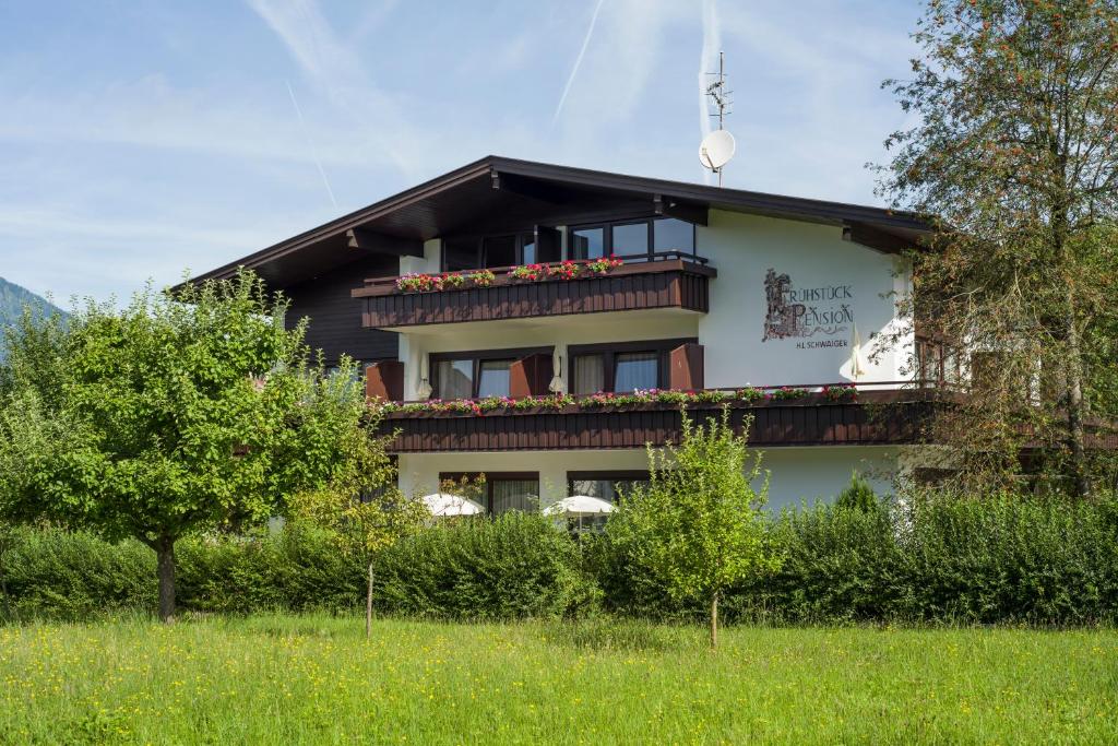ein Gebäude mit einem Balkon mit Blumen darauf in der Unterkunft Tirol Appartements Schwaiger in Niederndorf