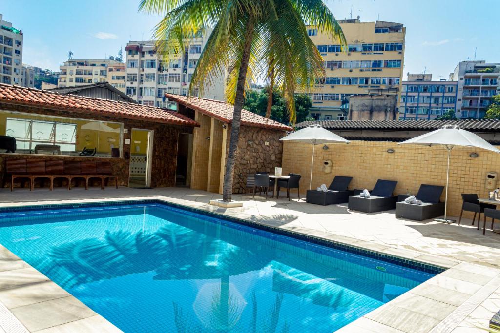 uma piscina com cadeiras e um edifício em Riale Imperial Flamengo no Rio de Janeiro