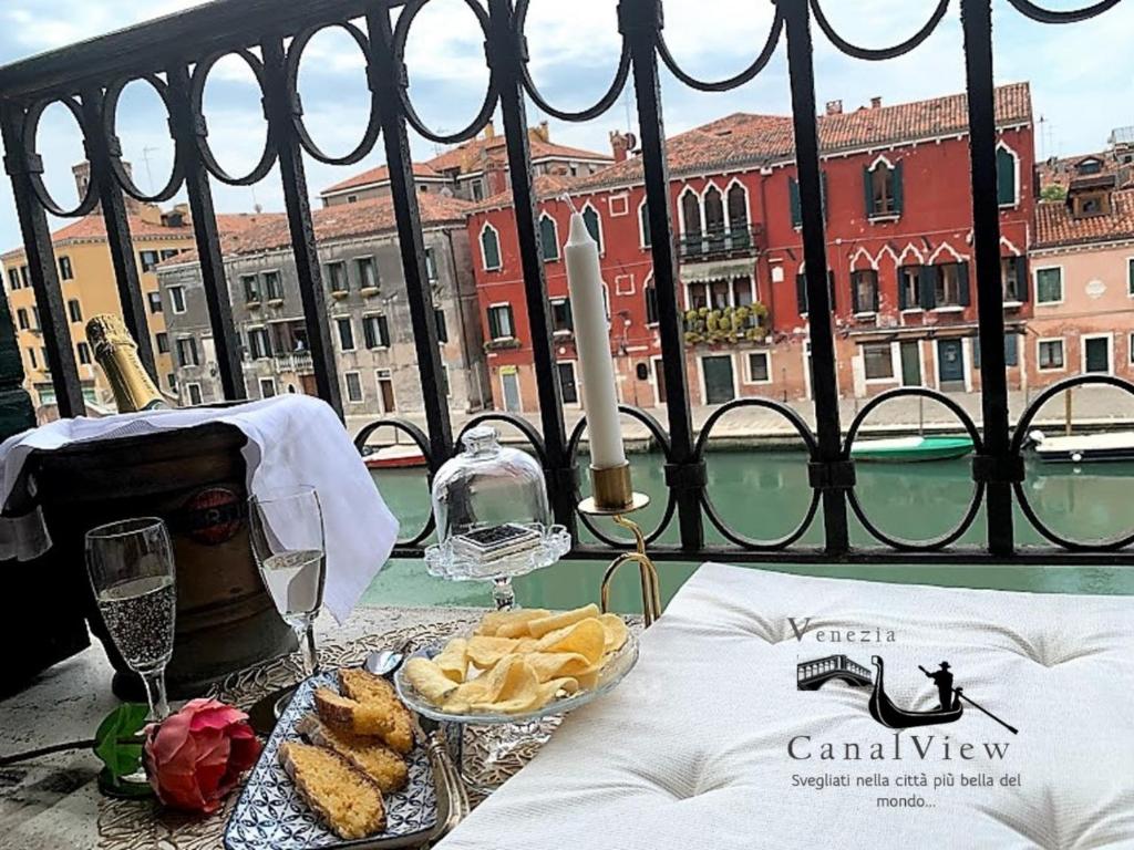 un tavolo con un piatto di pane e bicchieri di vino di Venezia Canal View a Venezia