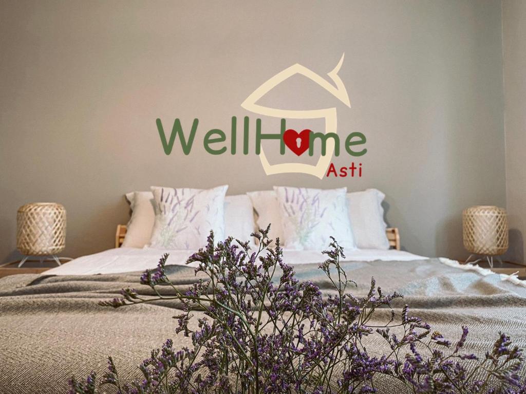 una camera con un letto con un cartello benessere sul muro di WellHome ad Asti