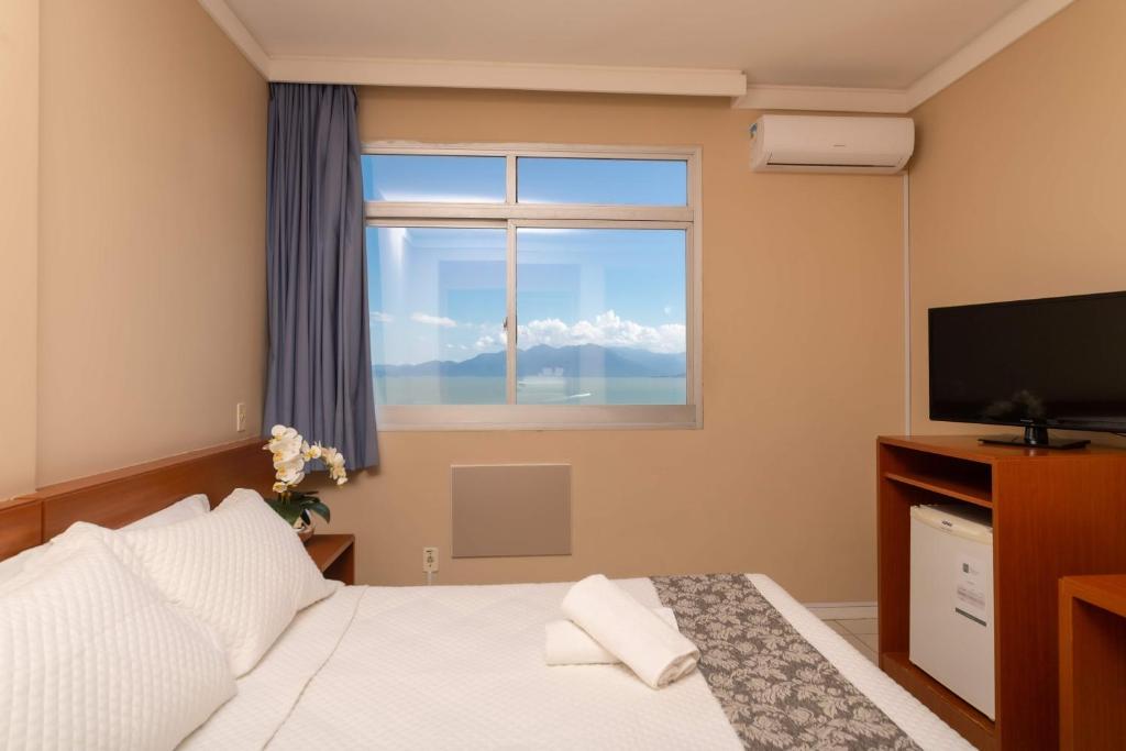 um quarto de hotel com uma cama e uma janela em Rede Andrade Cecomtur em Florianópolis