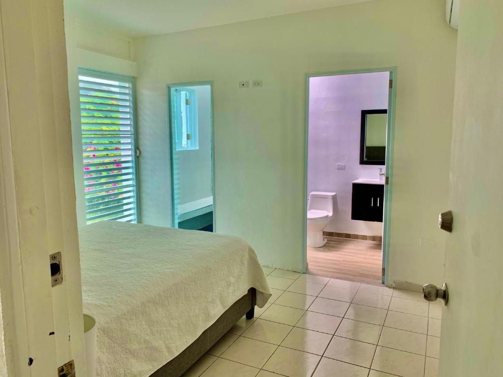 a bedroom with a bed and a bathroom with a tub at Villa del Carmen Boqueron in Cabo Rojo