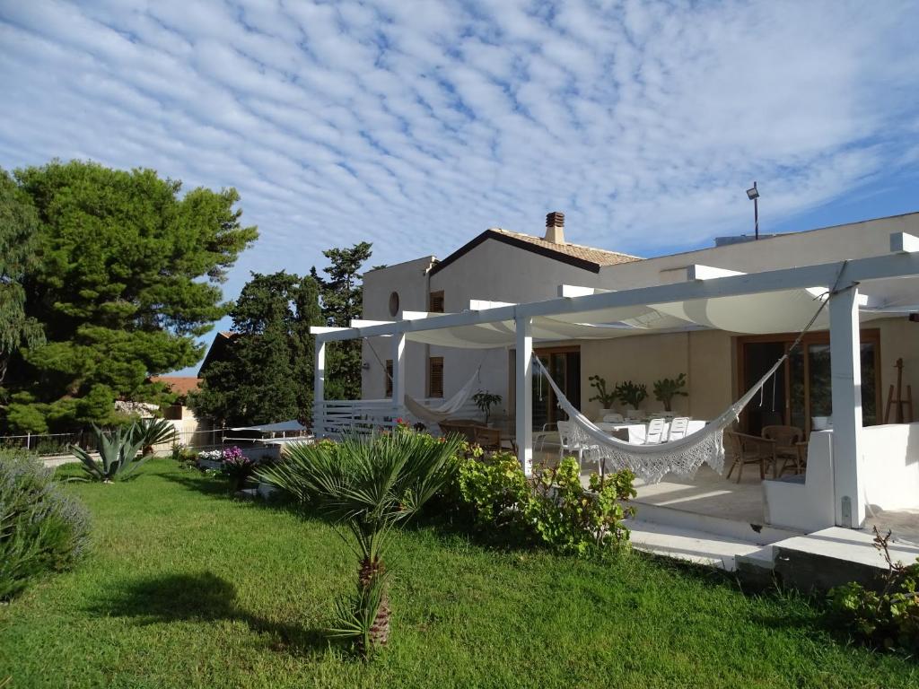 Biały dom z hamakiem na dziedzińcu w obiekcie Guesthouse Anchise 38 w mieście Pizzolungo