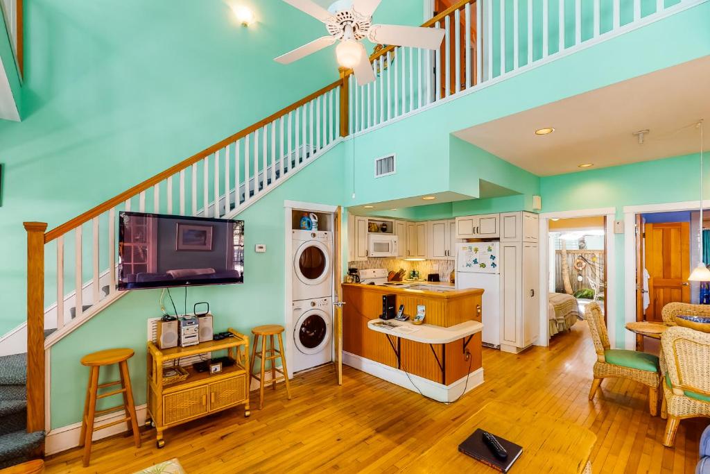 a living room with a staircase and a washer and dryer at Baya House in Key West