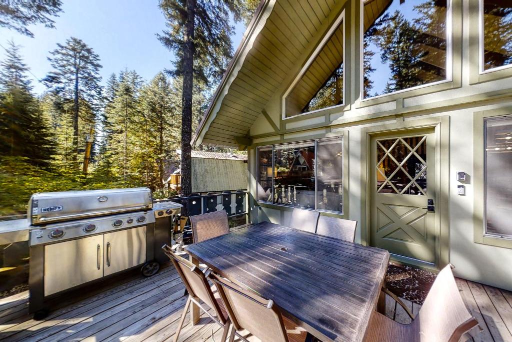 a wooden table and chairs on a deck with a grill at Lakedale Lodge in Ronald