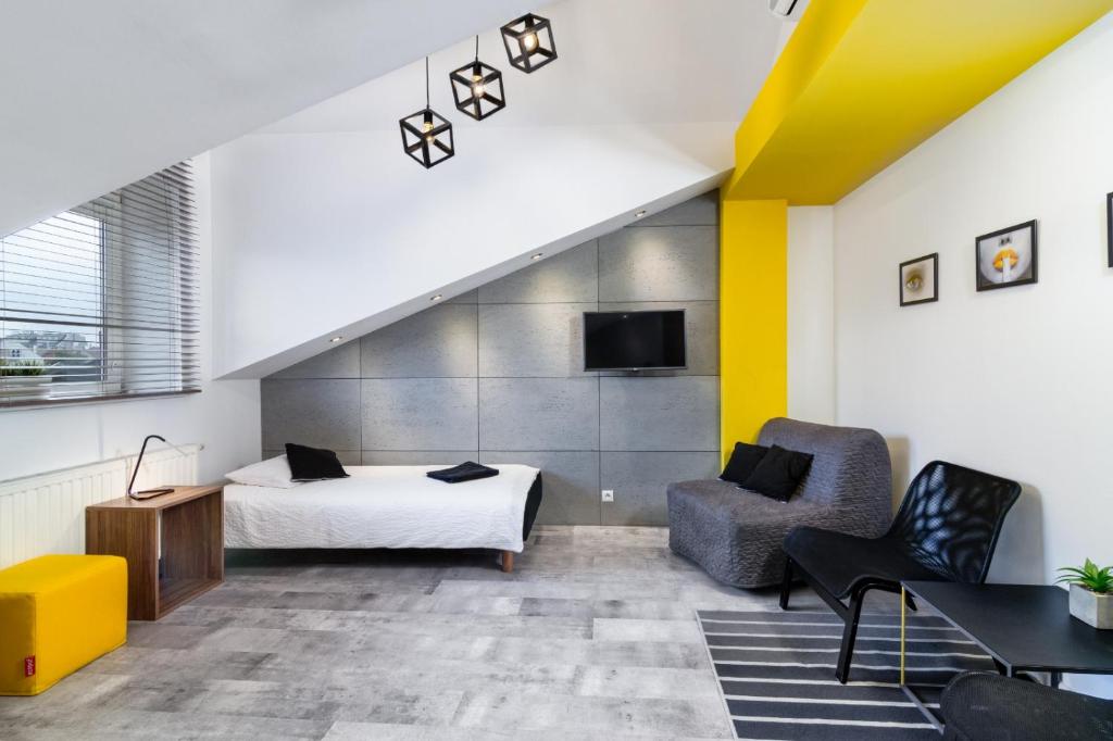 Pokój hotelowy z łóżkiem i krzesłem w obiekcie Rainbow Apartments 1 w Krakowie